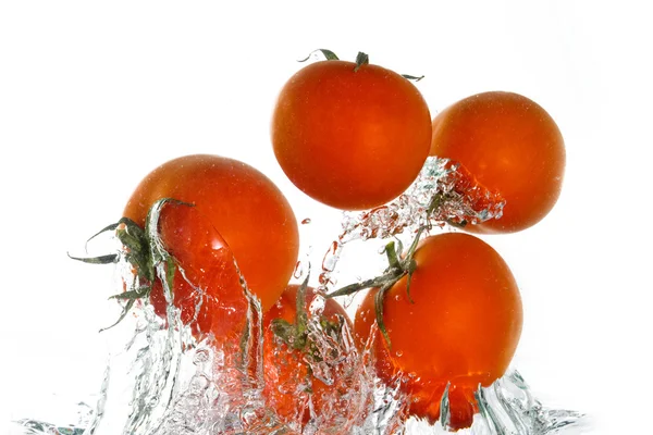 Tomatoes jumping out of the clear water — Stock Photo, Image