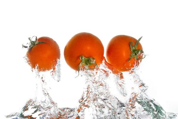 3 tomates saltando de la clara wate — Foto de Stock