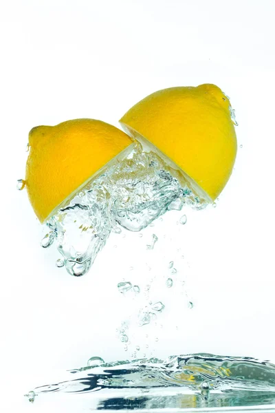 A sliced lemon jumping out of the clear — Stock Photo, Image