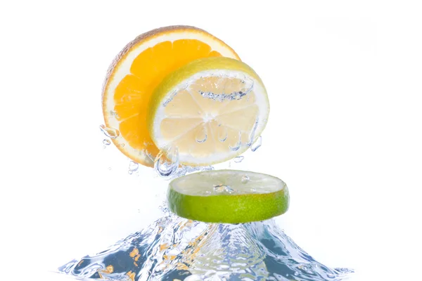 Slices of citrus fruit jumping out of th — Stock Photo, Image