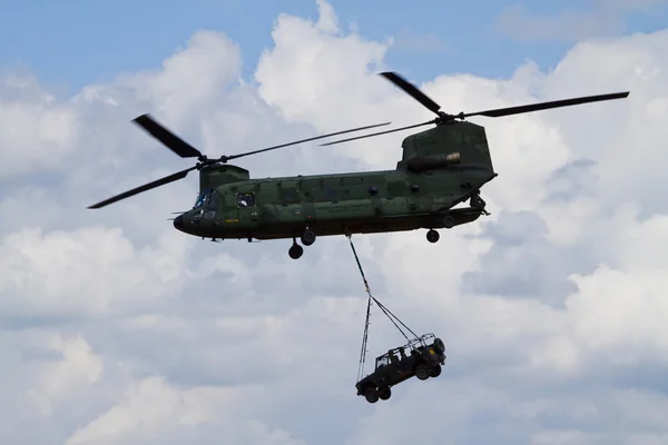 stock image A chinook helicopter carrying a jeep