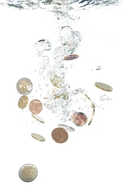 Euro-Münzen fallen ins klare Wasser Stockfoto