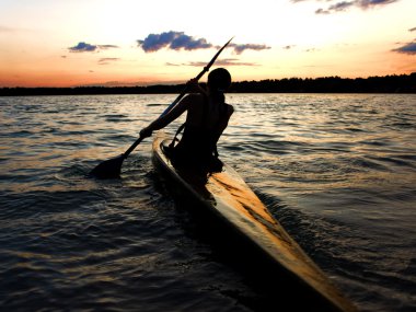 Kayaker against sunset clipart