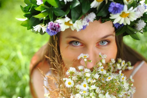 Mädchen mit einem Kreis von Blumen — Stockfoto