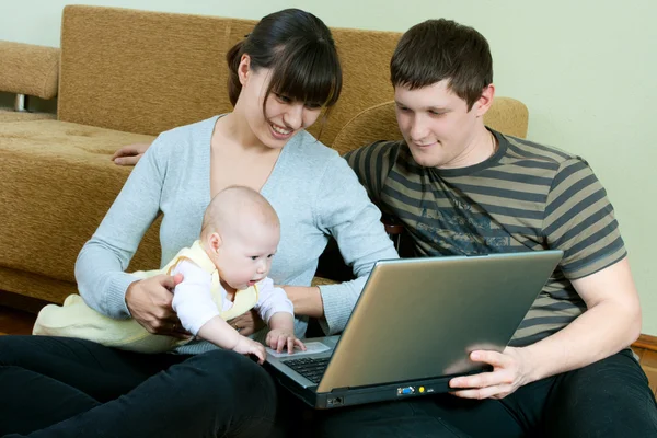 Lycklig familj med bärbar dator — Stockfoto