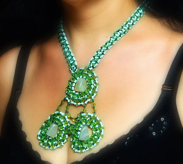 Ожерелье из стеклянных бусин зеленого цвета на шее — стоковое фото