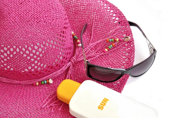 Hatt, flaska balsam solar och glasögon. — Stockfoto
