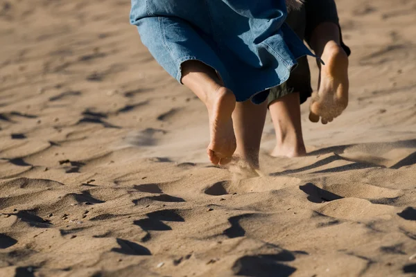 Piernas descalzas en la playa de arena — Foto de Stock