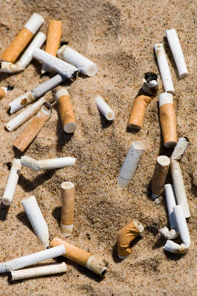 Colilla de cigarrillo en arena — Foto de Stock