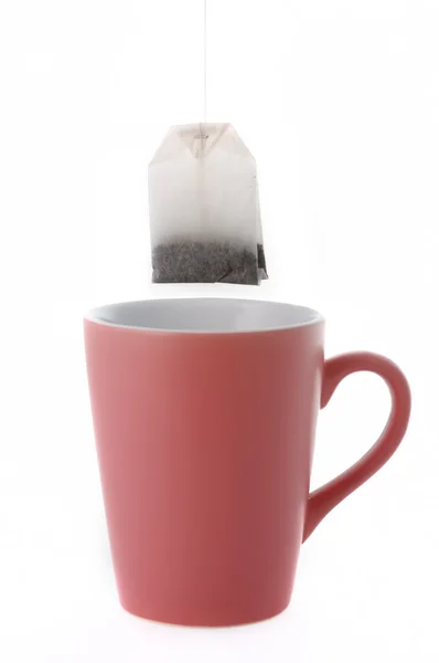 Copo com saco de chá no fundo branco — Fotografia de Stock