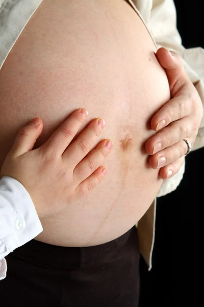 Mulher grávida e seu filho segurando barriga — Fotografia de Stock