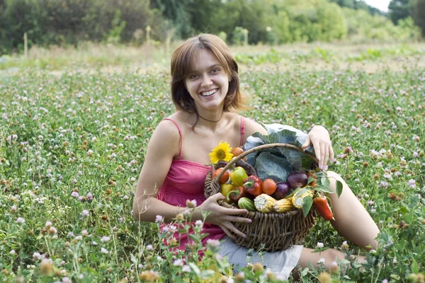 Flicka med en korg full av grönsaker — Stockfoto
