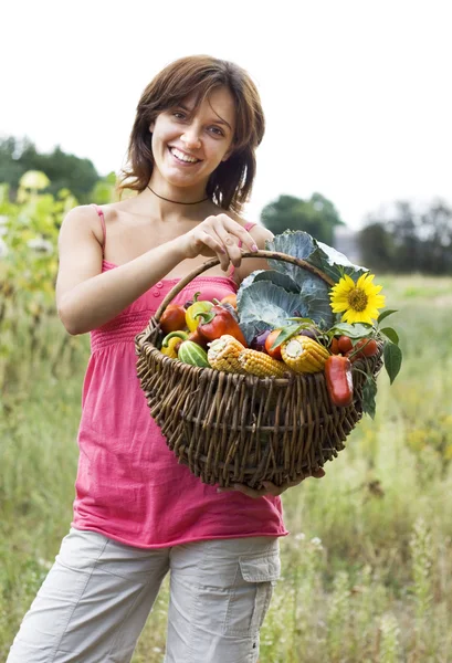 Chica con una cesta llena de verduras —  Fotos de Stock
