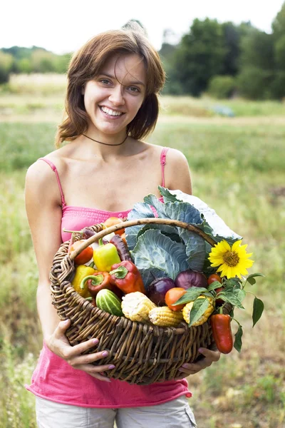 Menina com uma cesta cheia de legumes — Fotografia de Stock