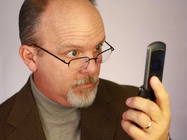 Человек смотрит на мобильный телефон — стоковое фото