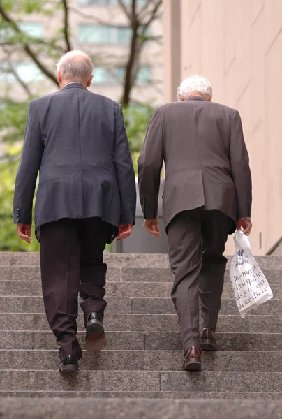 Deux vieux hommes d'affaires marchant dans les escaliers Images De Stock Libres De Droits
