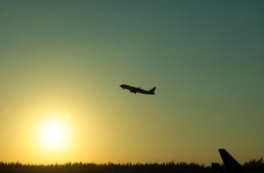 Orange sunrise with airplane silhouette clipart