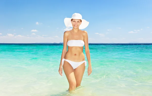Donna in cappello in piedi sulla spiaggia — Foto Stock