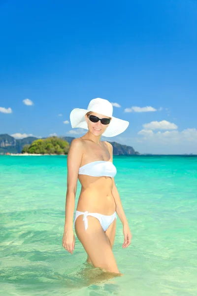 Donna in cappello in piedi sulla spiaggia — Foto Stock