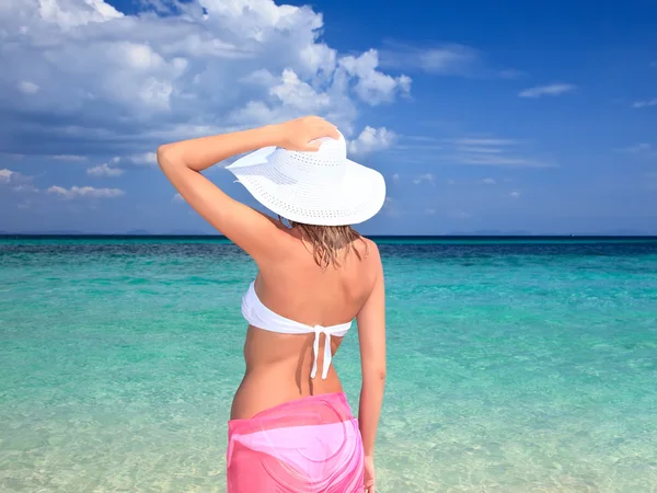 Mulher com chapéu de pé na praia — Fotografia de Stock