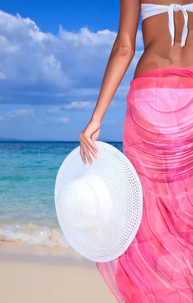 Žena s kloboukem stojící na pláži — Stock fotografie