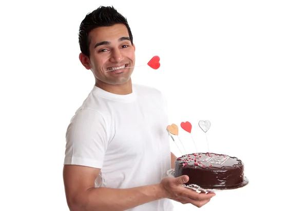 Mann hält Schokoladenkuchen verzierte Herzen — Stockfoto