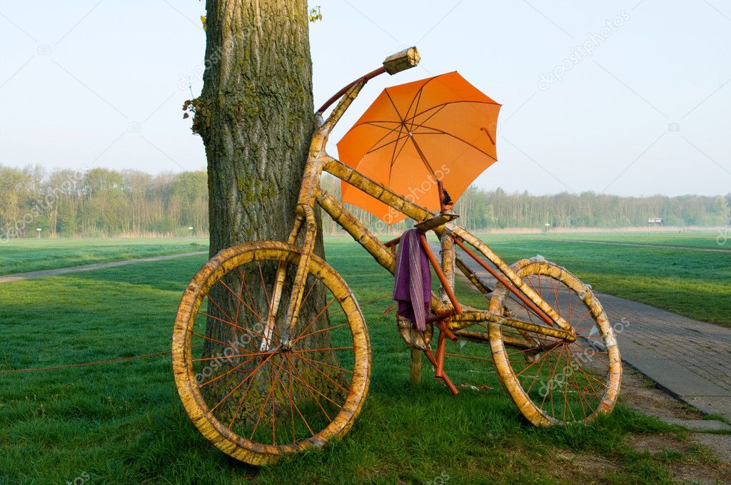 A big bycicle with an umbrella