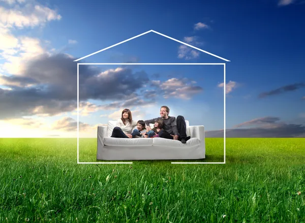 Familia sentada en un sofá en el prado —  Fotos de Stock
