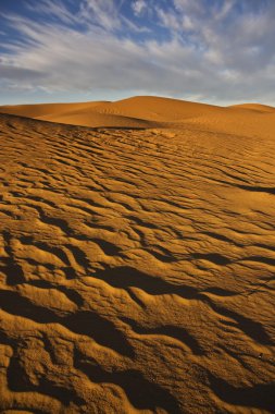 Sand dunes with cloudy sky clipart