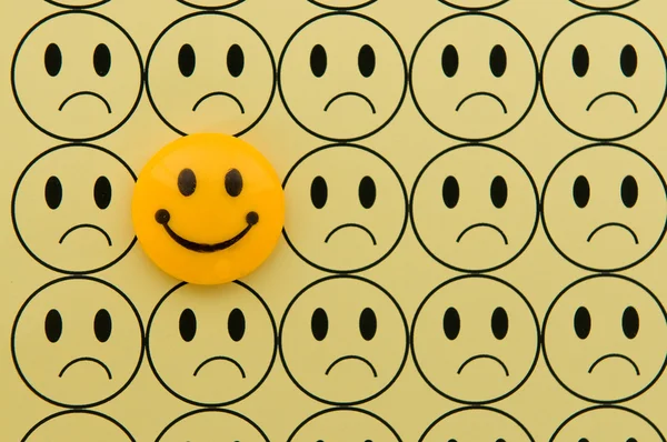 Gul smiley mot ledsen emoticon — Stockfoto