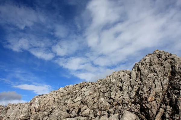 Felsen am blauen Himmel und Wolken Hintergrund — Stockfoto