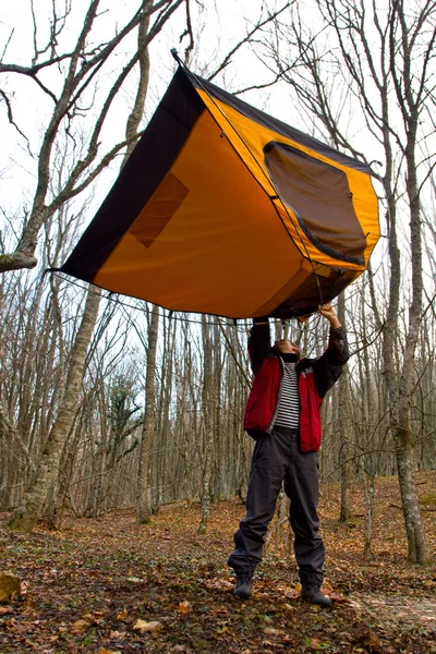 Man keep tourist tent over head — Stock Photo, Image