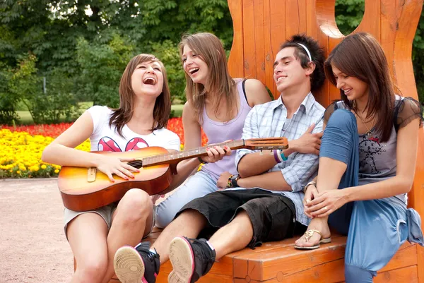 Vier junge Freunde spielen Gitarre — Stockfoto