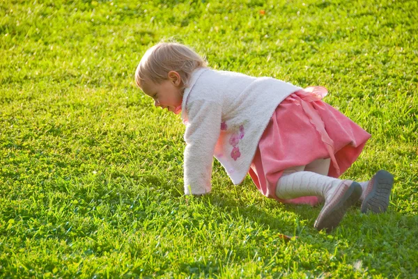 Menina brincando na grama — Fotografia de Stock