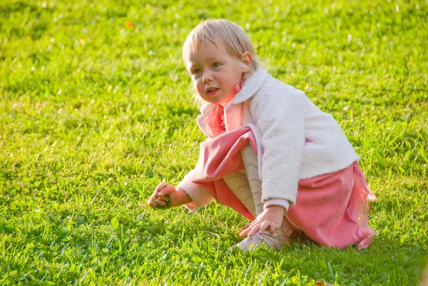 A kislány-játék a fűben — Stock Fotó