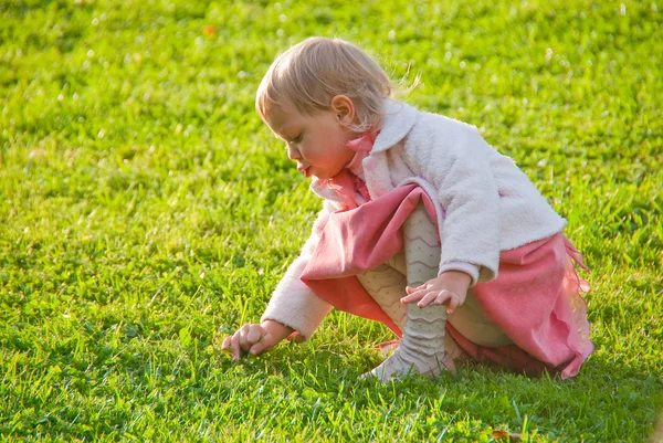 Menina brincando na grama — Fotografia de Stock