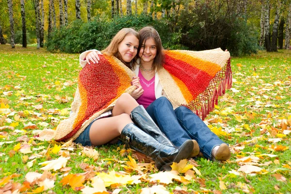 Två flickor sitta i parken hösten — Stockfoto