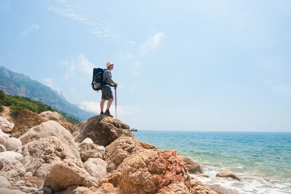 Туристы на каменистом берегу моря — стоковое фото