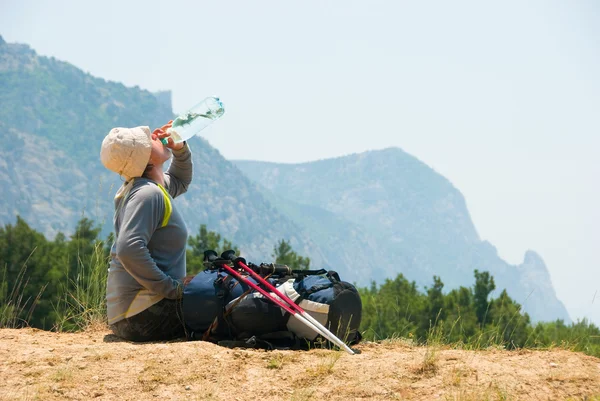 Уставший турист пьет воду — стоковое фото