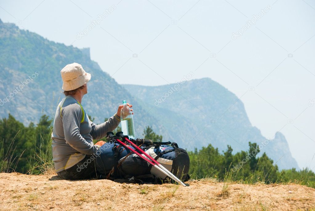 Tired hiker relaxes on a hill