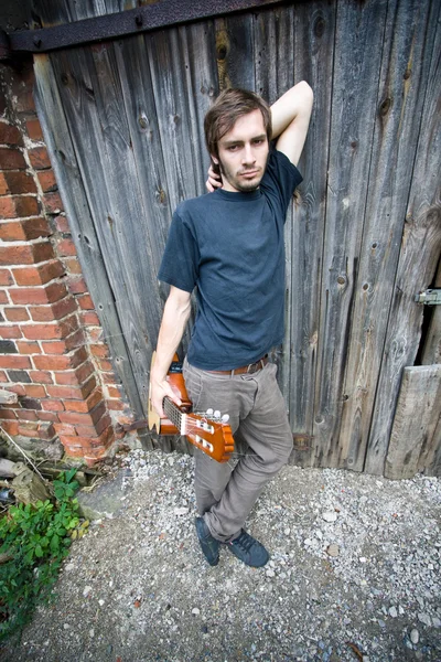 Грубий сільський хлопець тримає свою гітару — стокове фото