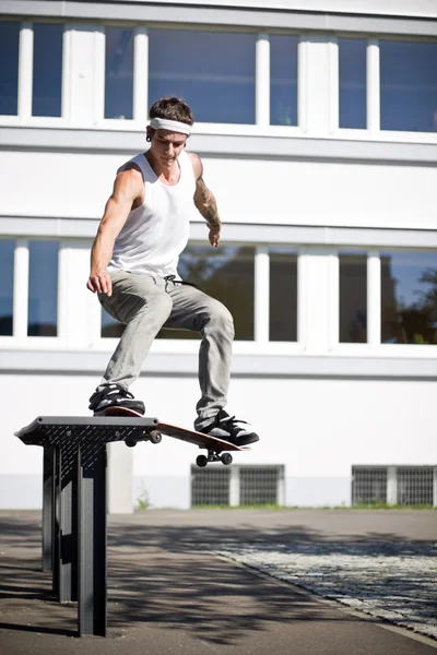 Skate fare uno scivolo con il suo skateboard — Foto Stock