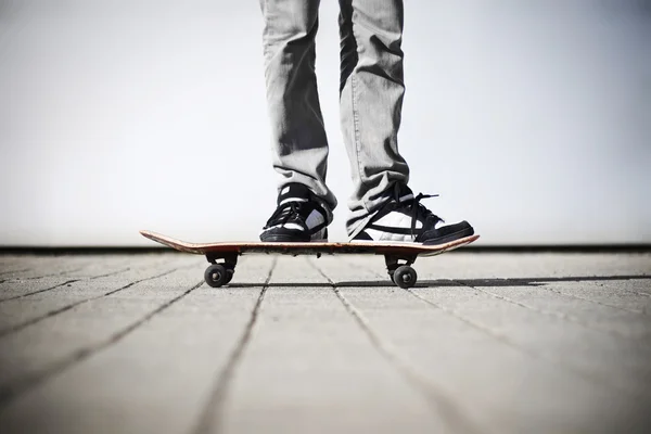Bruslař, stojící na jeho skateboard — Stock fotografie