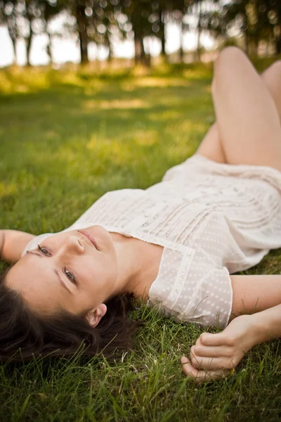 Женщина в зеленой траве расслабляется — стоковое фото