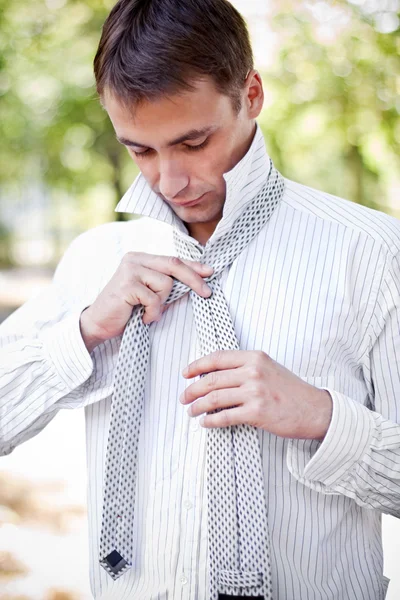 Business man making his tie — Stock Photo, Image
