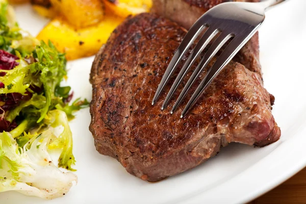 Gros plan d'une fourchette argentée sur un steak — Photo