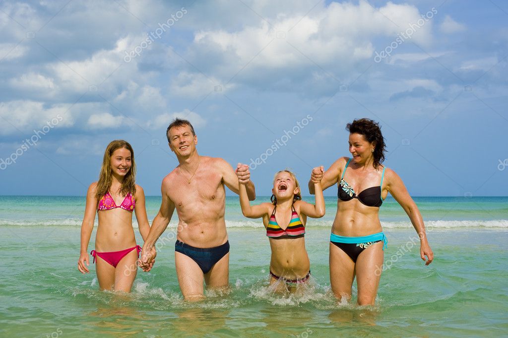 Happy family in a swimsuit in the pool Stock Photo by