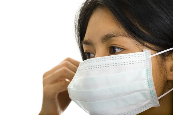 Woman putting on a face mask — Stock Photo, Image
