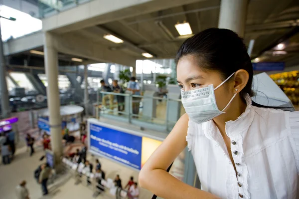 Com máscara de gripe no aeroporto — Fotografia de Stock
