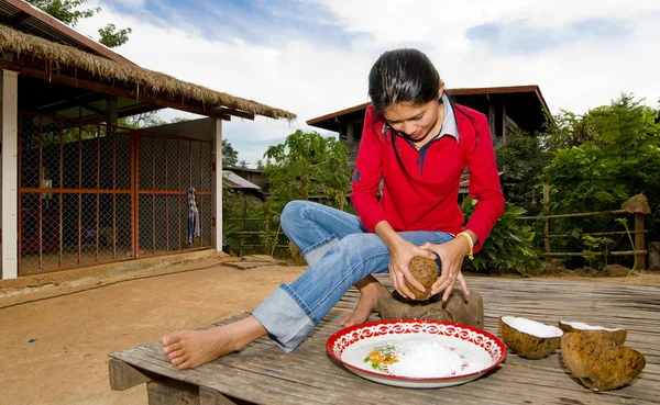 Тайская девушка вытаскивает кокосовое мясо из скорлупы — стоковое фото